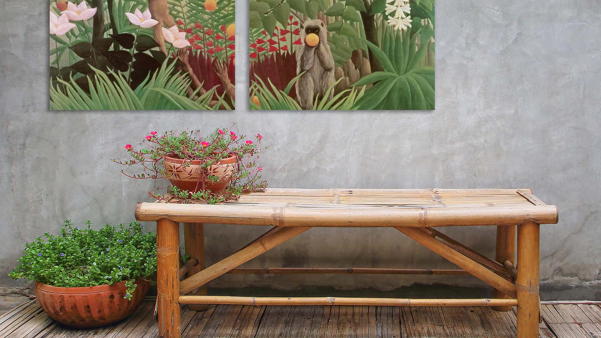 Bamboo garden table and plant pot in courtyard with concrete wall and monkey artwork hanging
