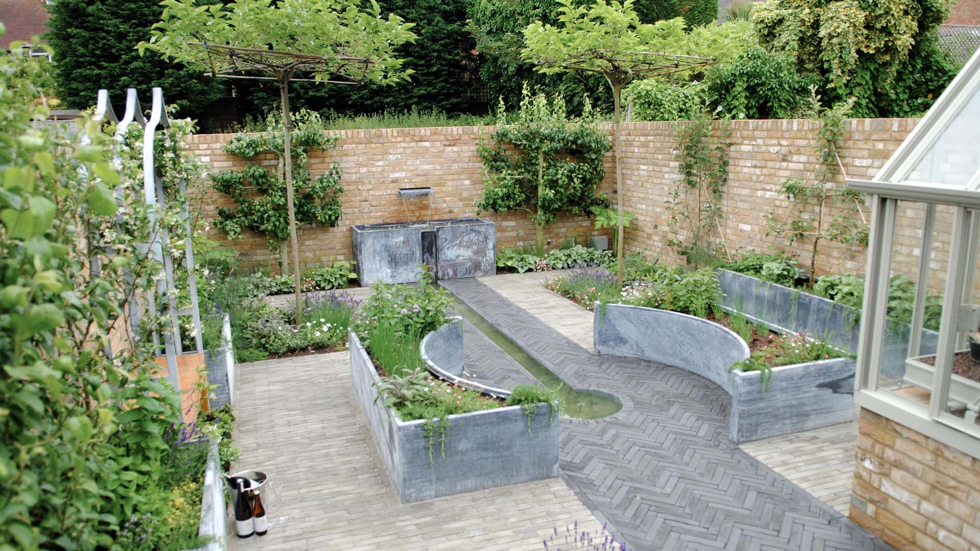 Courtyard garden with central water feature and trees planted on the walls
