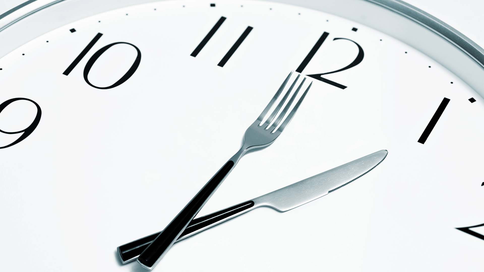 Close-up of a clock face with a knife and fork as the hands 