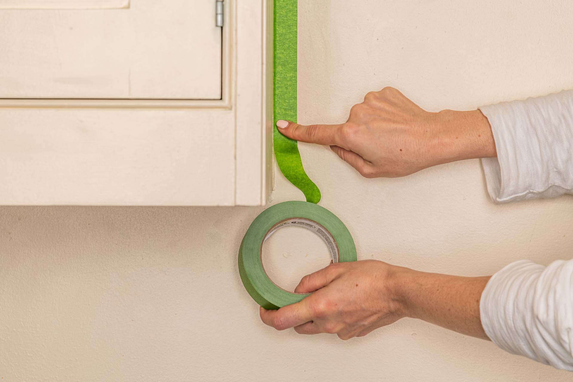 green masking tape being applied around a cabinet