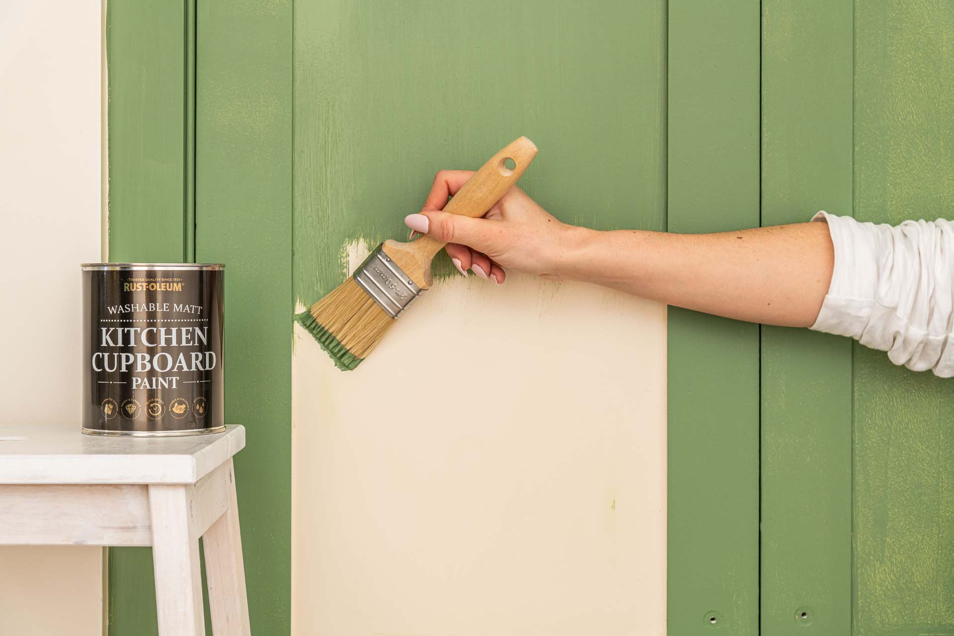 A cabinet door being painted green