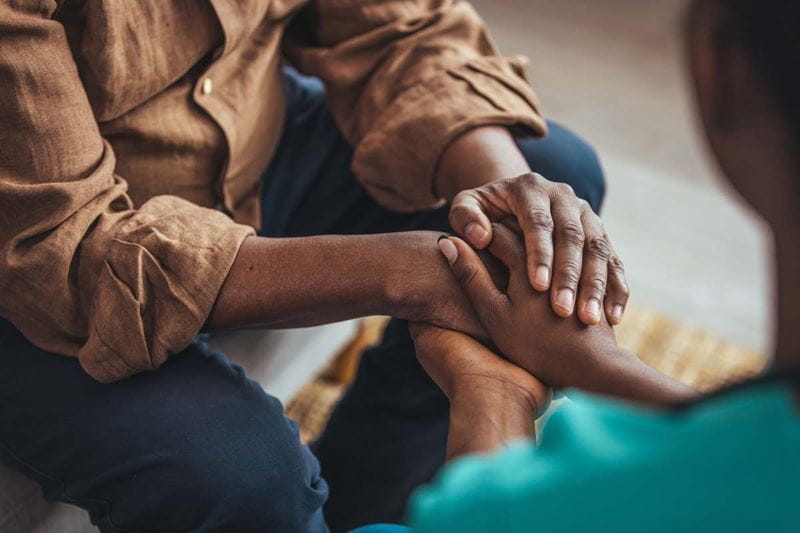 two people comforting each other with their hands on top of each others