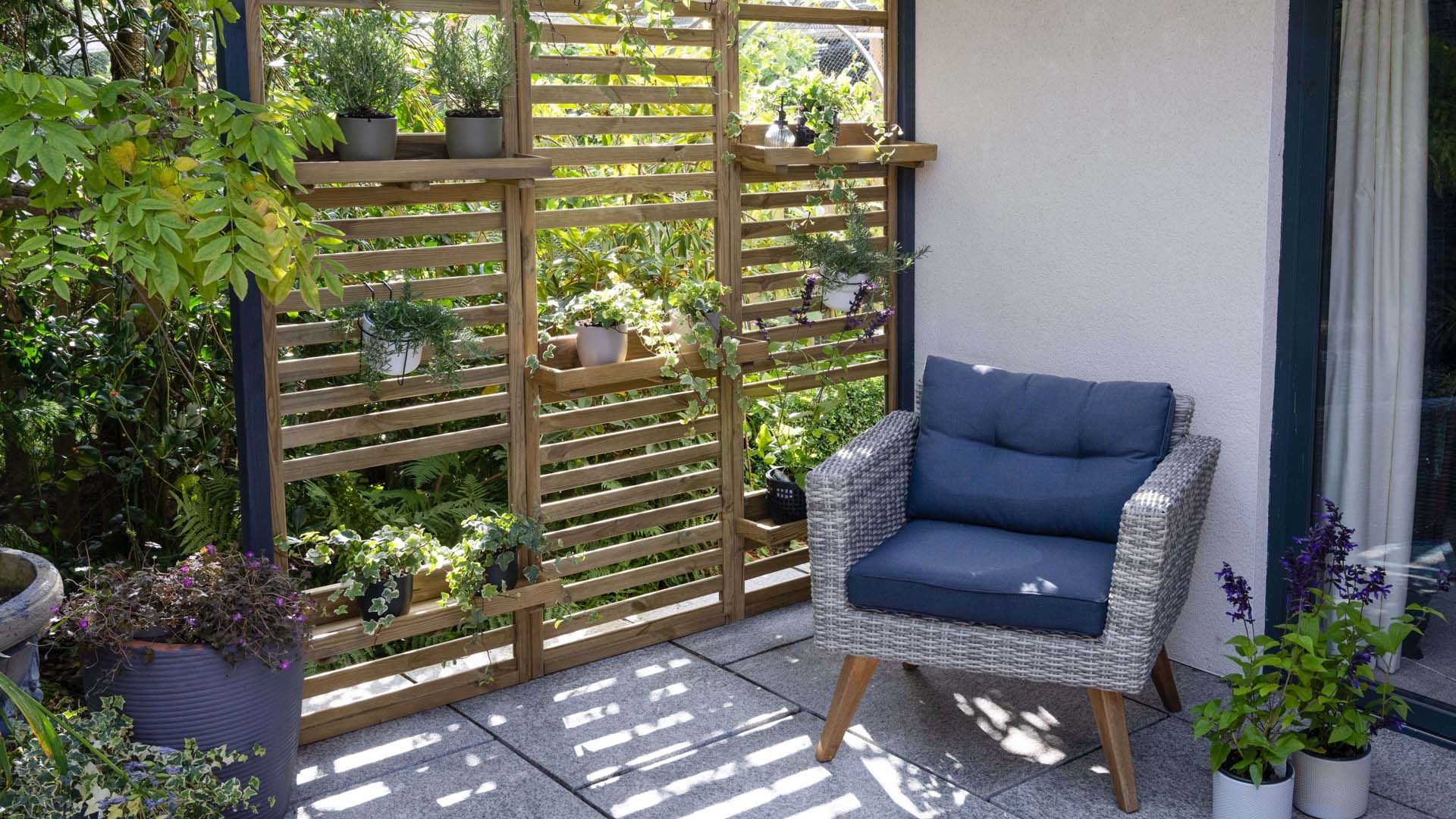 Garden wall planter with blue chair in front