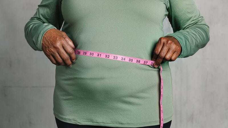 Woman measuring waist with tape measure