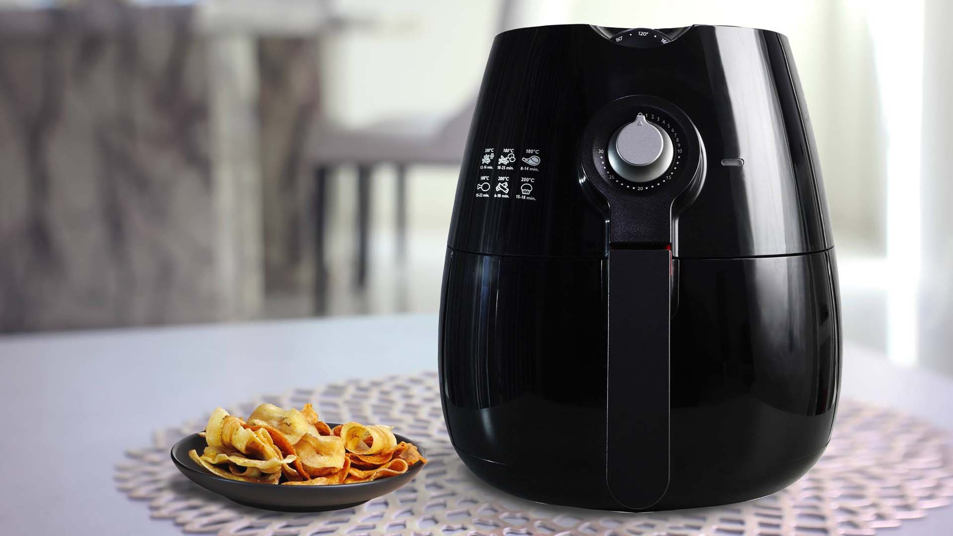 A plate of crisps next to an air fryer