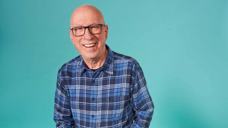Ken Bruce smiling in a plaid shirt