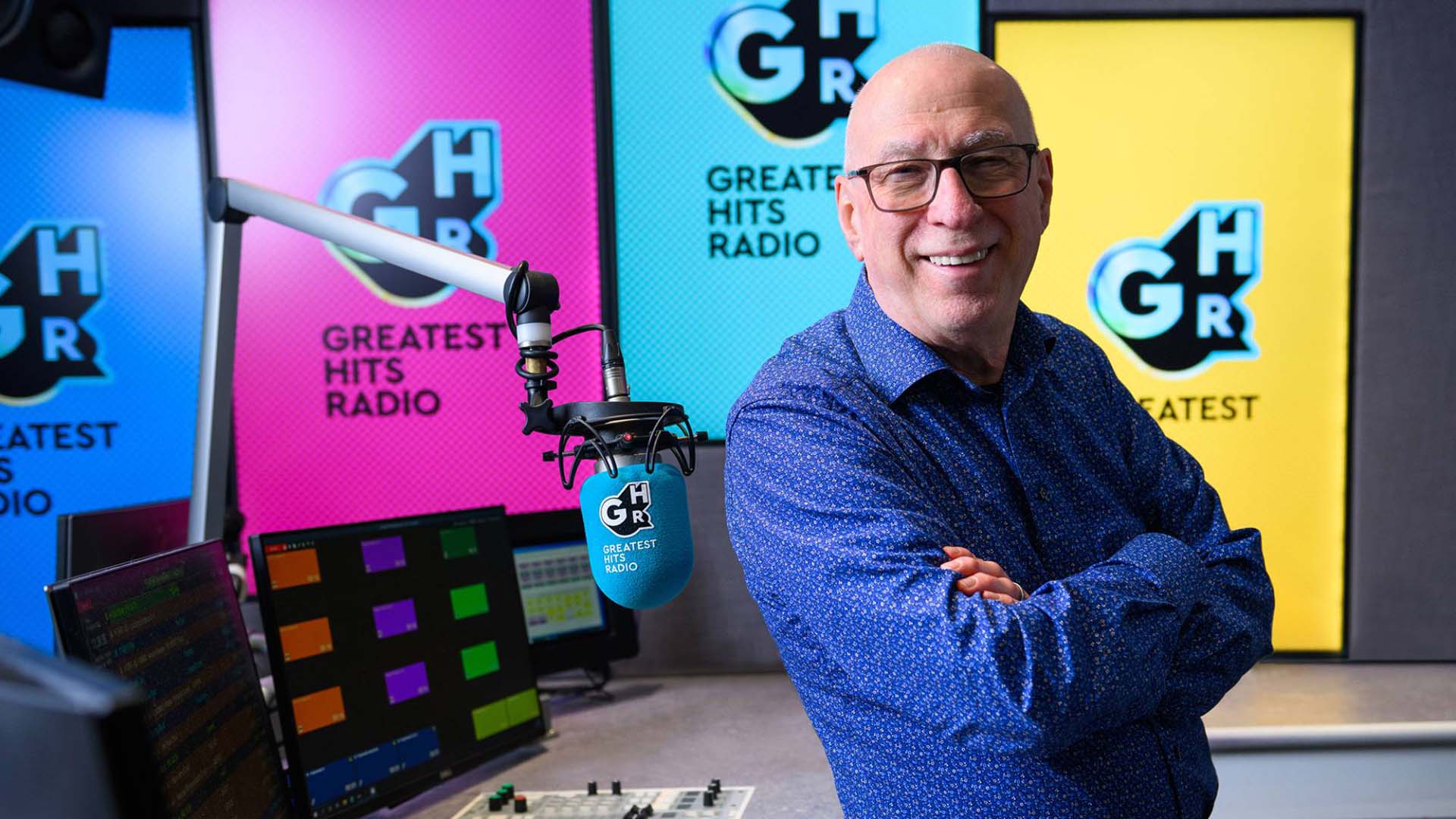 Ken Bruce with a microphone in the Greatest Hits Radio studio