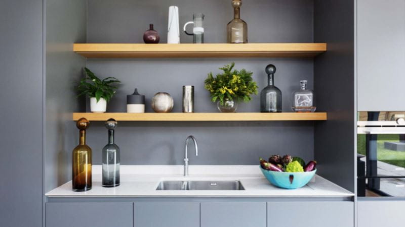 This kitchen by Hux uses limited space above the sink for shelves which are purely dedicated to decorative vases and plants