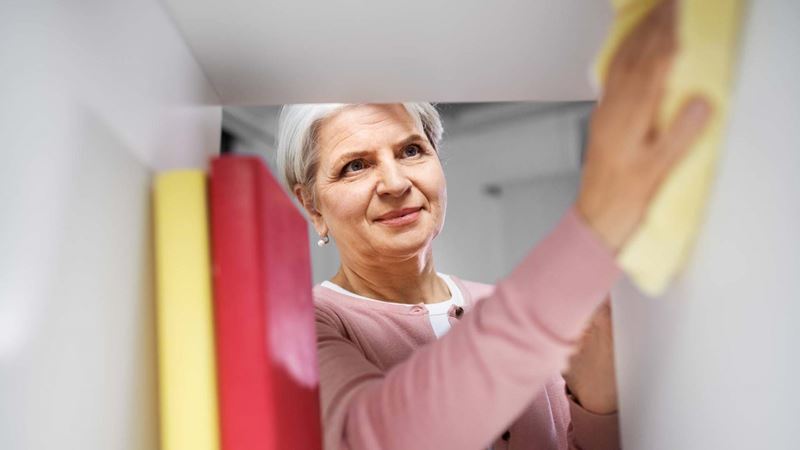 woman cleaning inside the cupboard with a cloth
