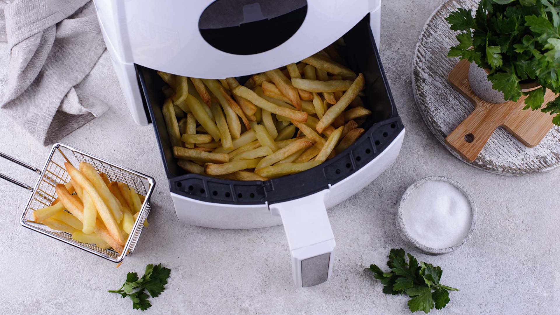 An open air fryer drawer taken from above, filled with chips