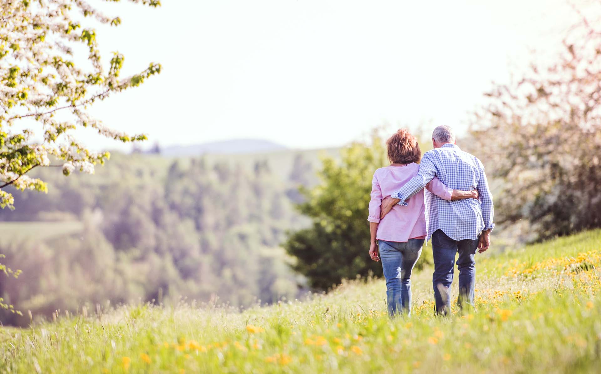 a couple walking through a spring meadow