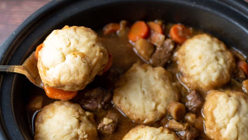 A stew with dumplings cooking in an air fryer