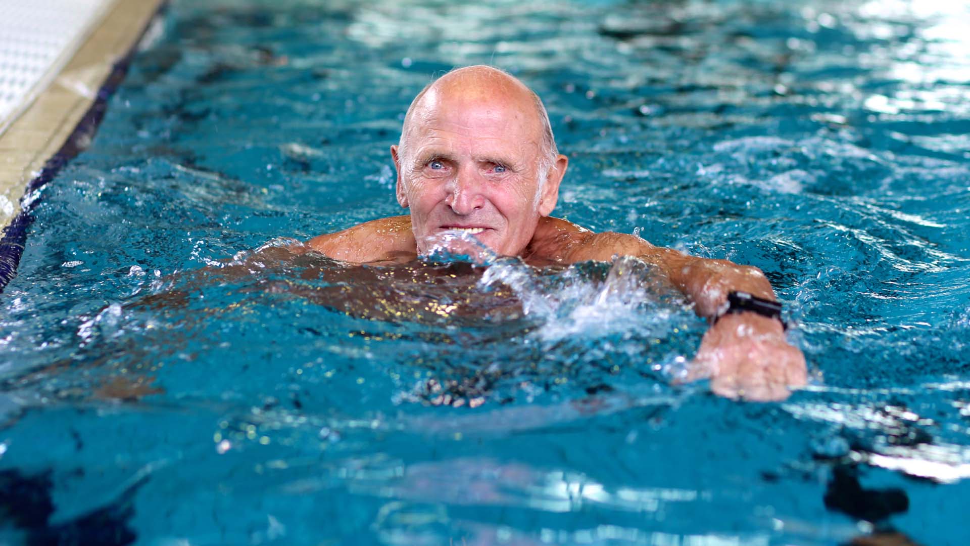 Happy man swimming in a pool