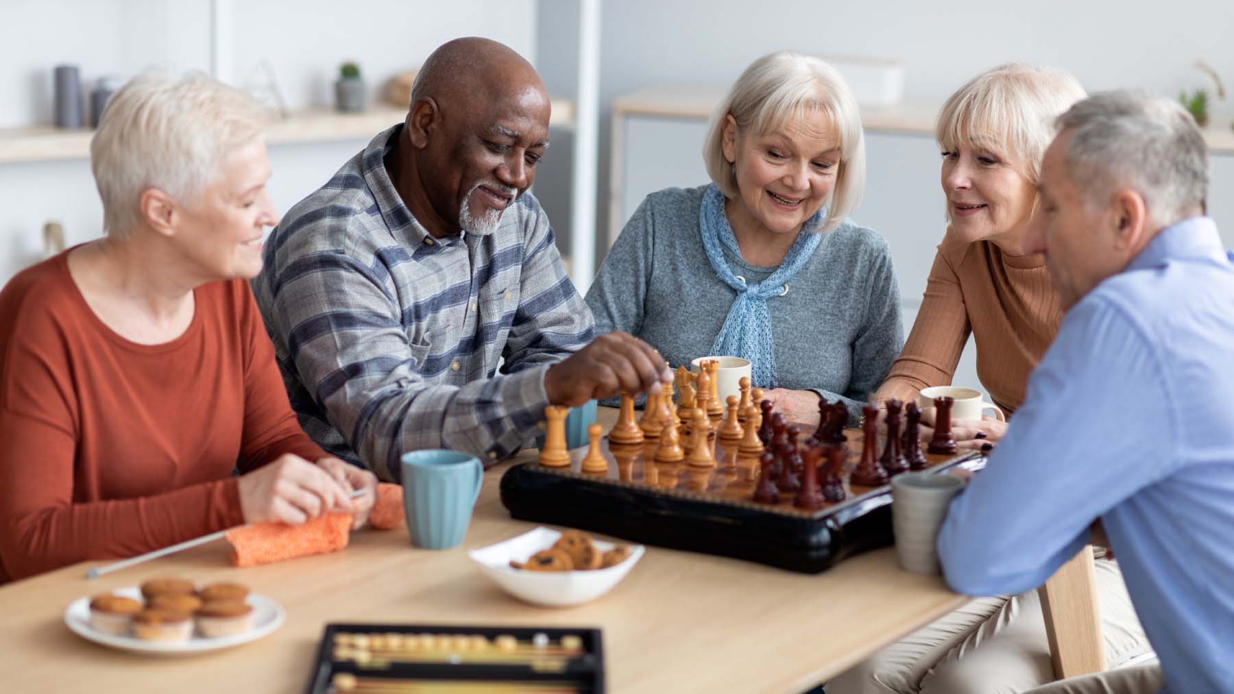 A group of people sitting around a chess board