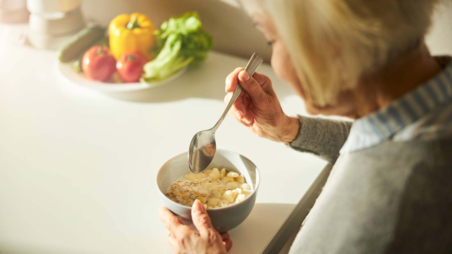 woman sitting down to eat oats from a bowl