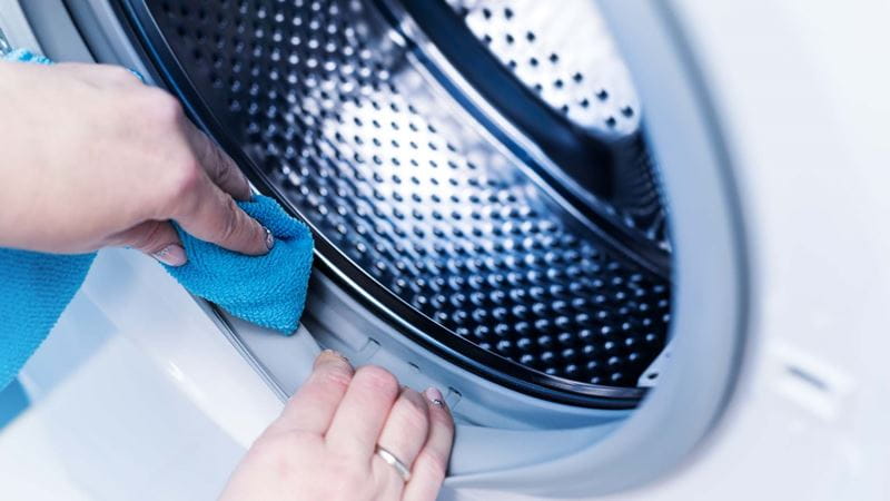hand cleaning washing machine seal with a blue cloth