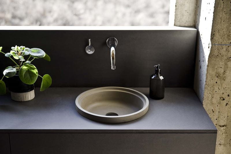 An outdoor round sink with a black surround