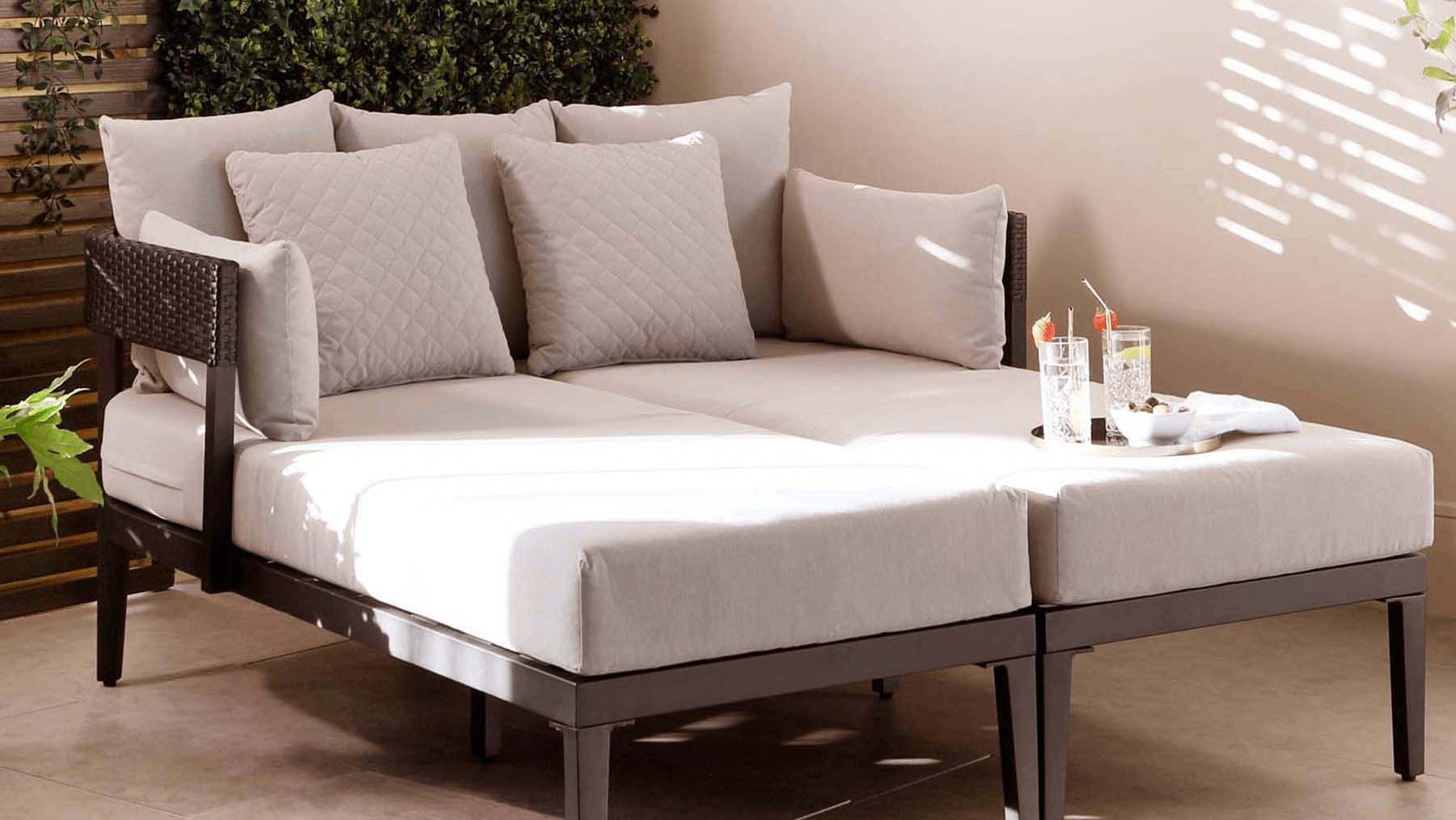 Two chaise longues, pushed together become a large daybed in an interior garden area