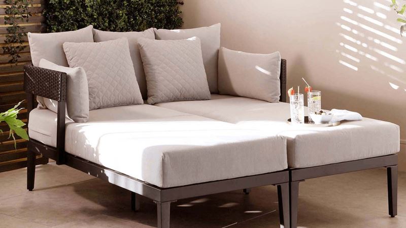 Two chaise longues, pushed together become a large daybed in an interior garden area