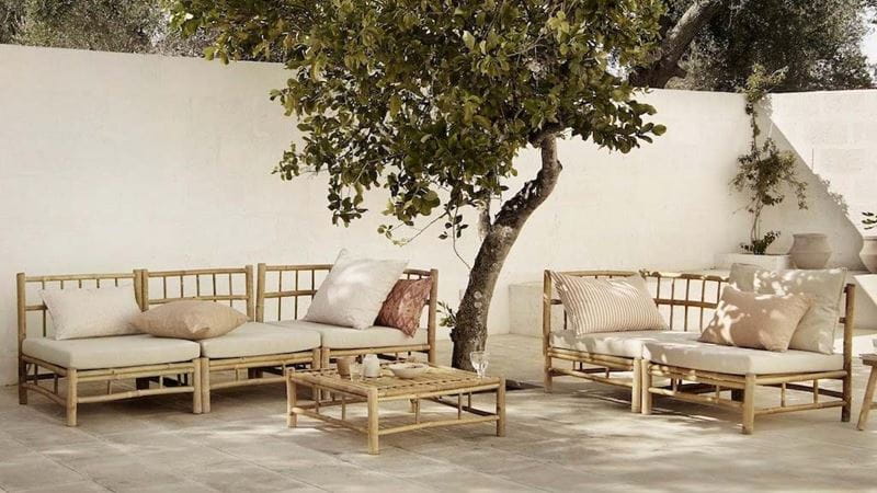 Modular bamboo garden seating in a bright white and cream patio with a single tree