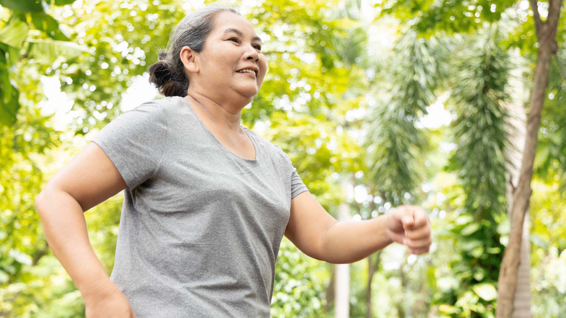 Old senior woman running, jogging, exercising, Jeffing in green park, breathing clean air, good and healthy life quality and wellness concept image