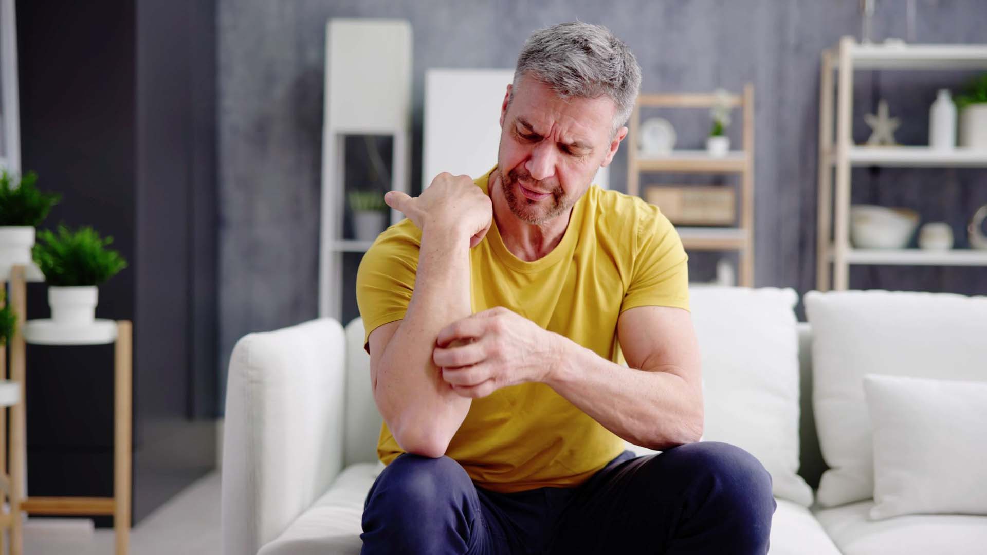 Man scratching itchy arm