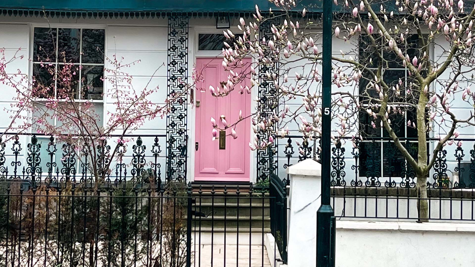pink front door on a white house