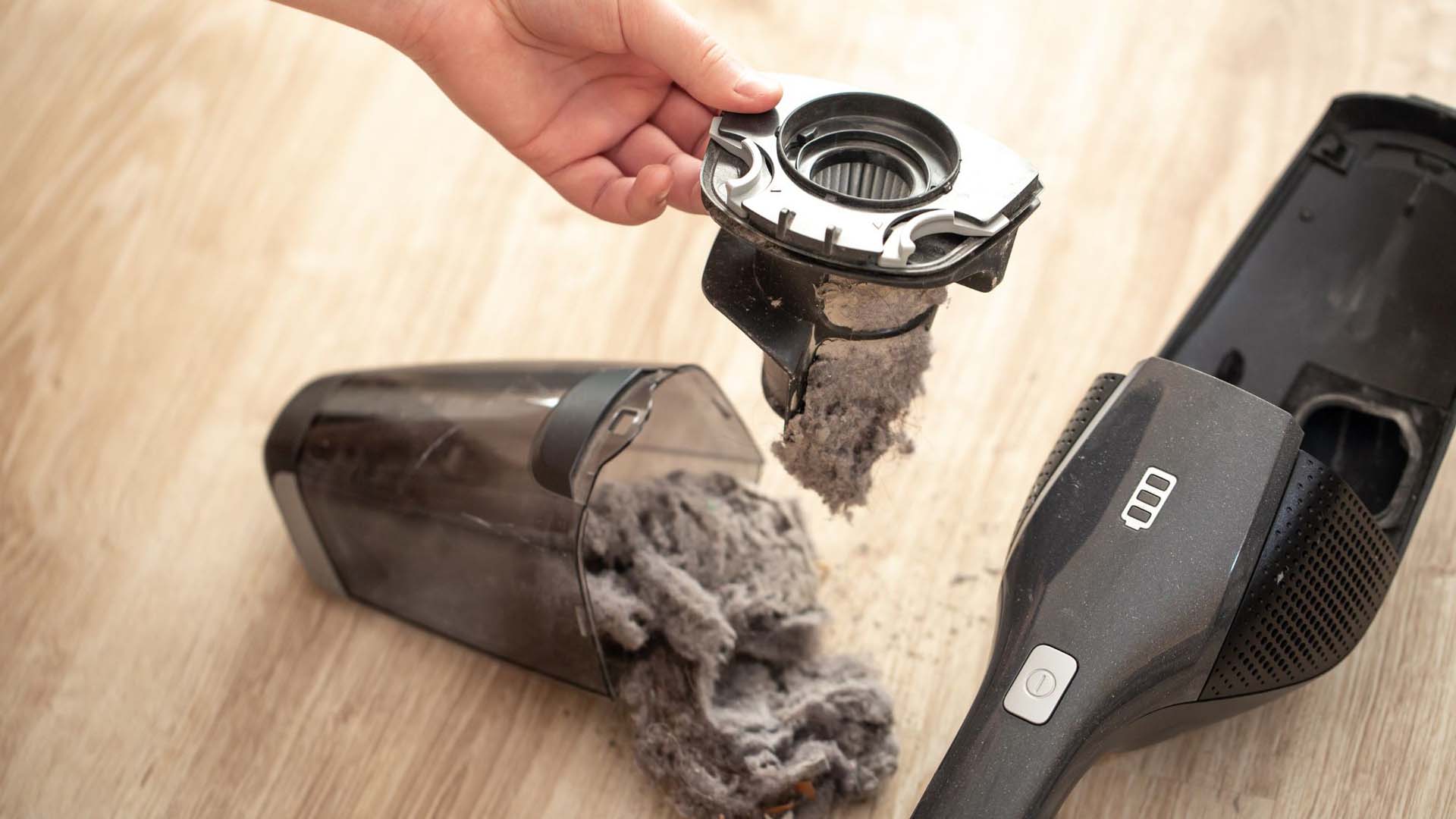 someone emptying a very clogged and full hoover compartment