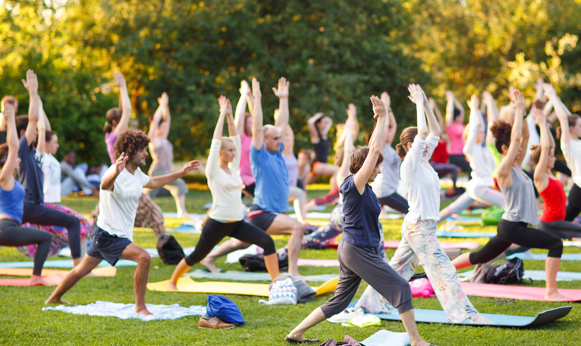 large group in the park practicing yoga