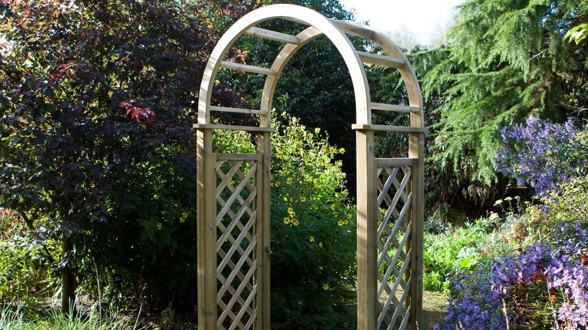 A wooden arch doorway surrounded by plants