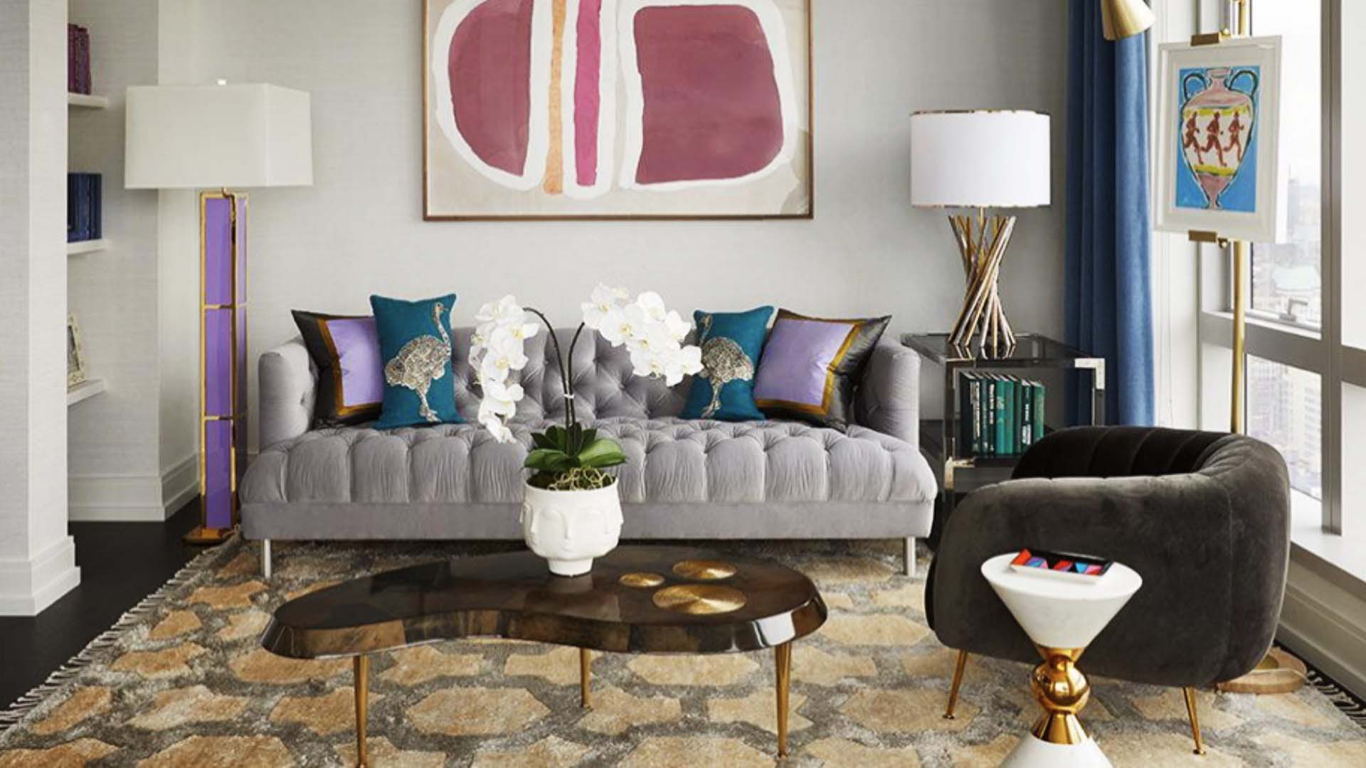 A modern and artistic sitting room with a grey couch and brown armchair, a printed rug and modern art