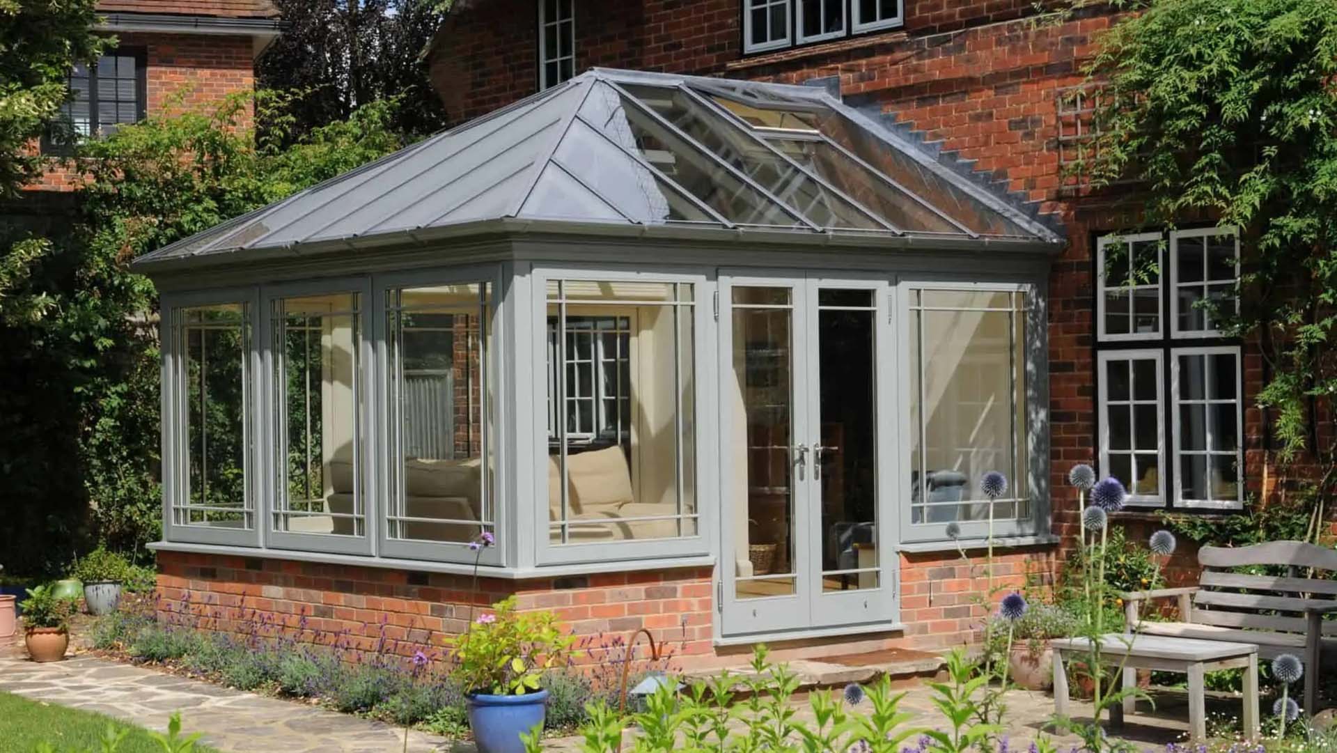 A grey Edwardian conservatory with a lower brick portion