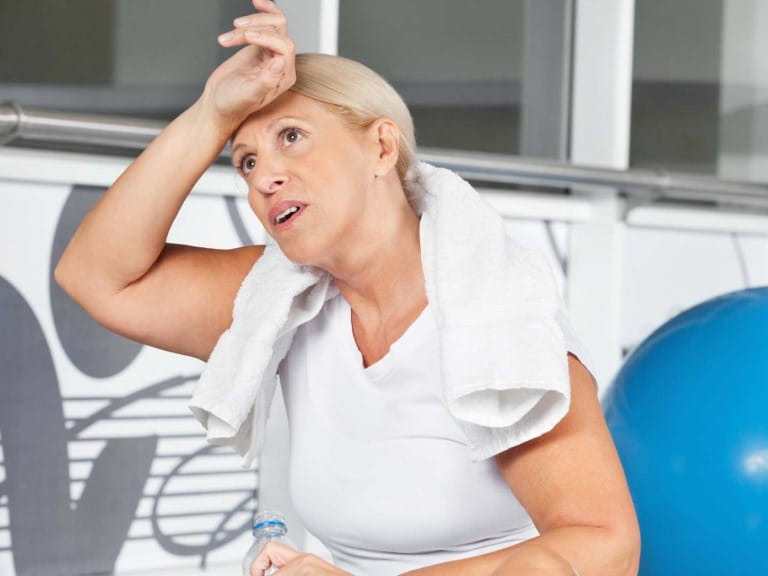 A woman looks hot after exercising in the heat | Shutterstock/Creative Family