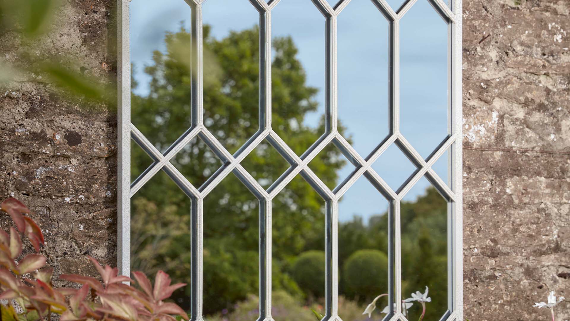A mirror disguised to look like a white trellis window