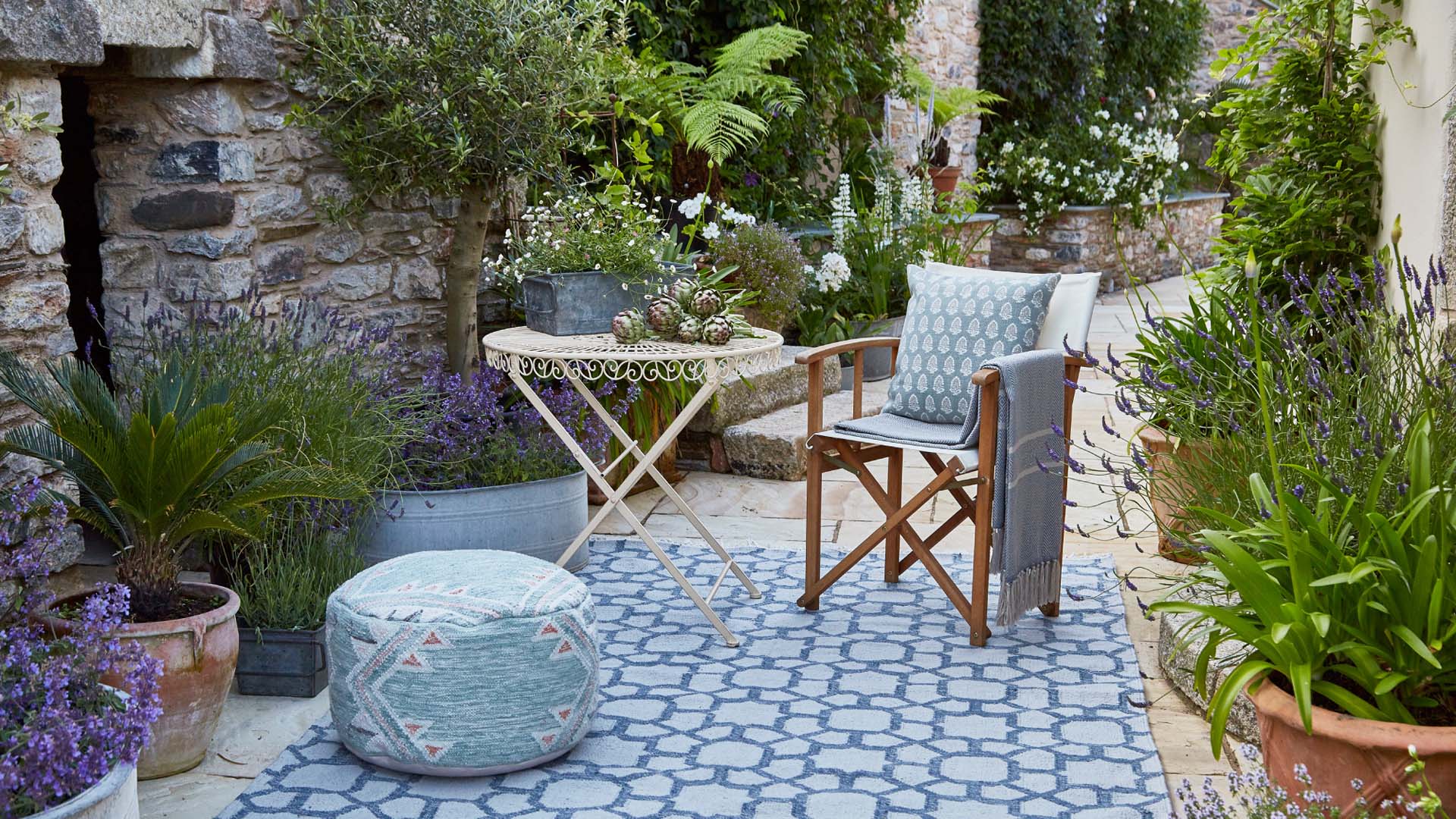 Potted plants surrounding a central rug