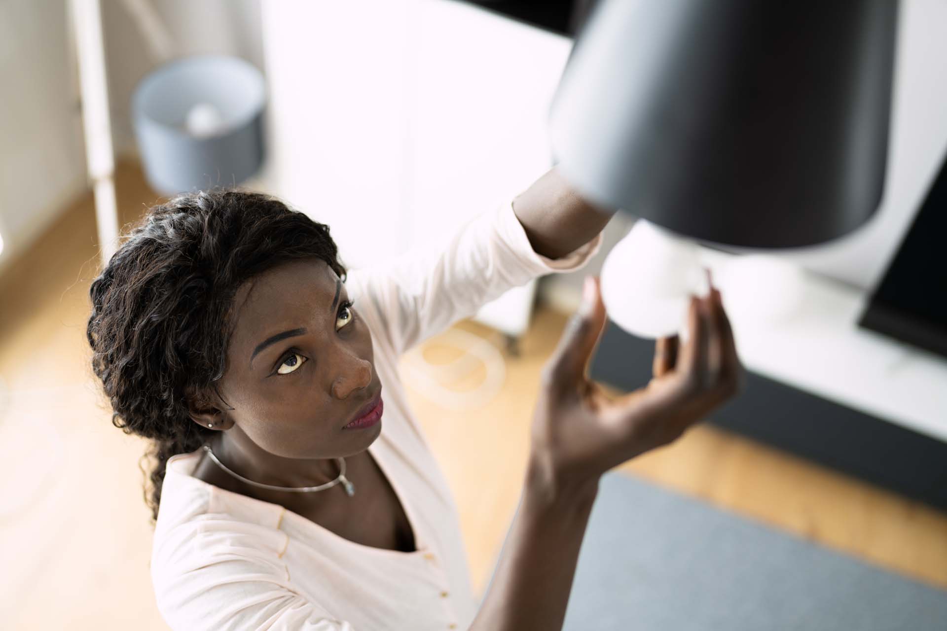 A woman changing a lightbulb