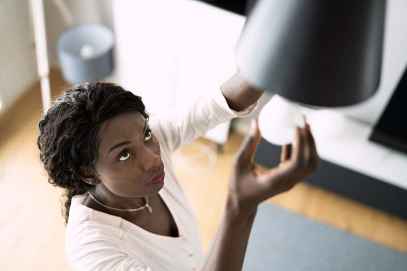 A woman changing a lightbulb