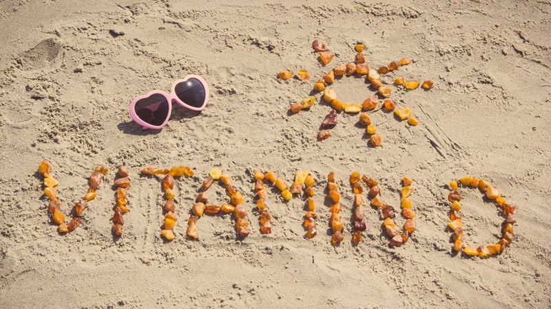Vitamin D written in the sand with shells