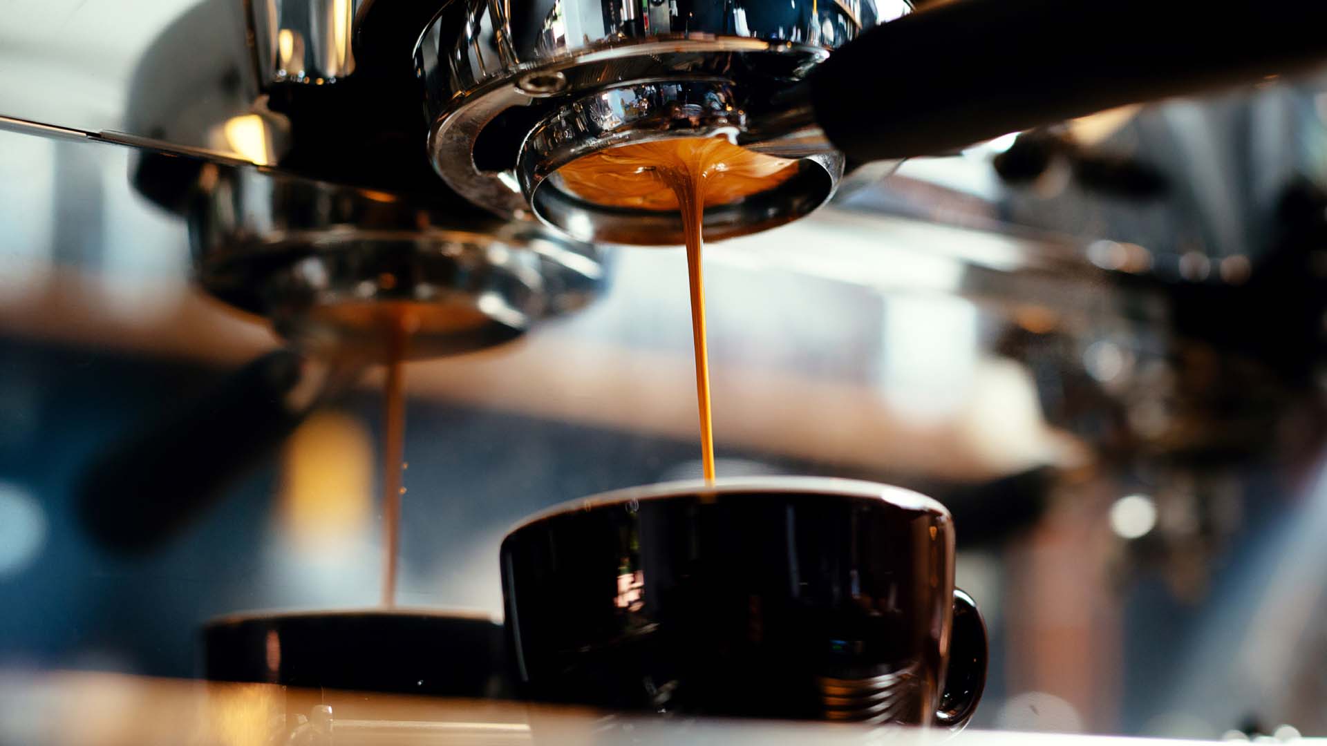 A coffee machine pours espresso into a mug