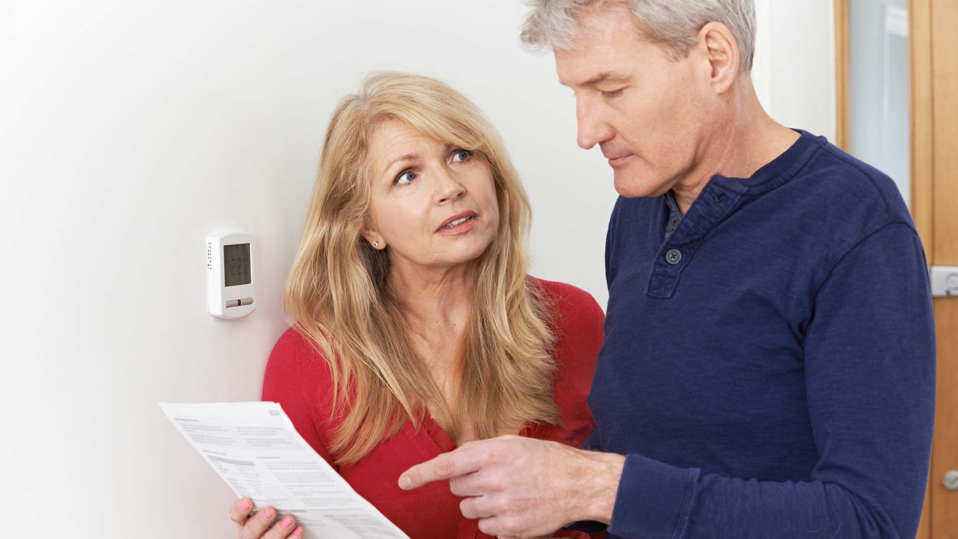 A man and a woman looking at a sheet of paper with concern