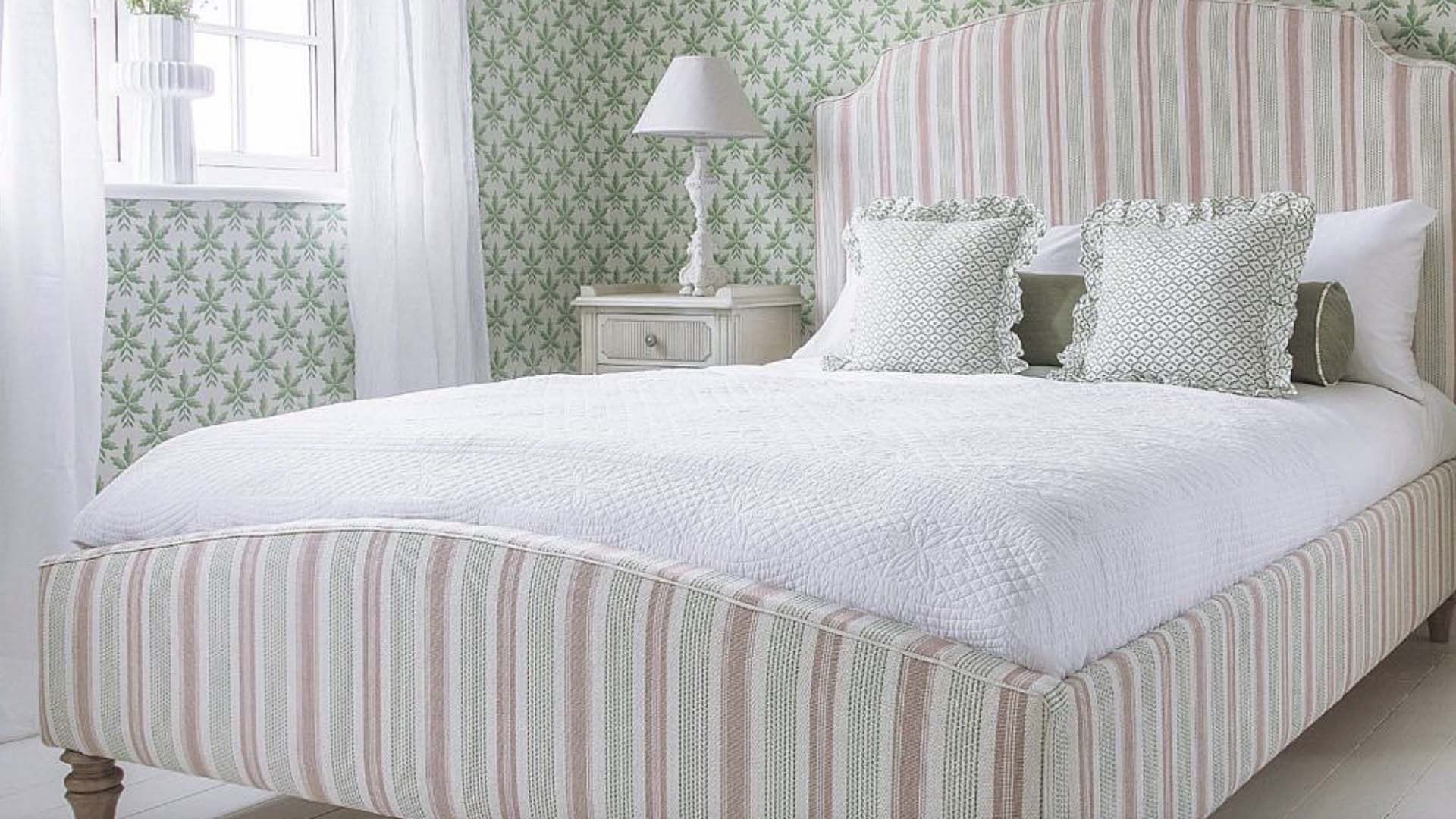 striped bed with green wallpaper