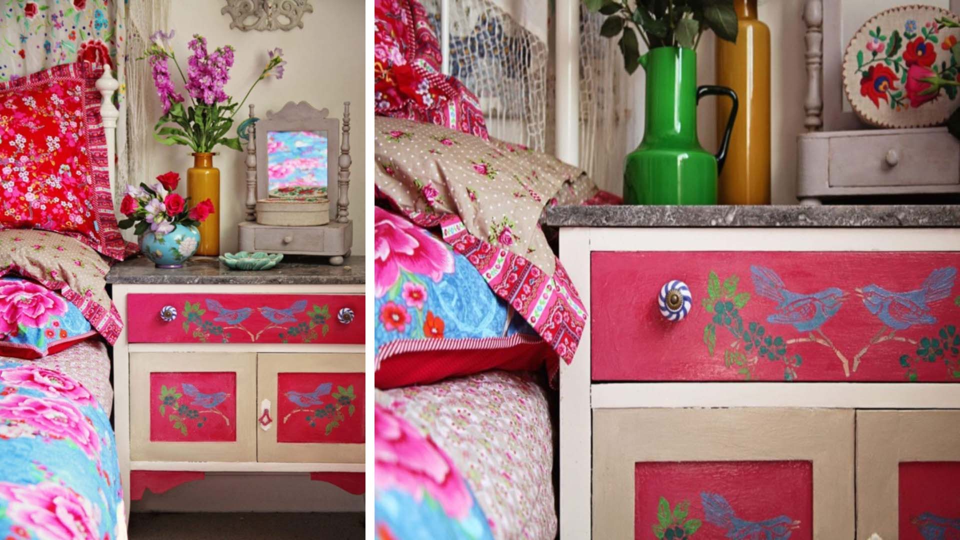 A bedside table painted in pinks and floral patterns to match colourful bedding