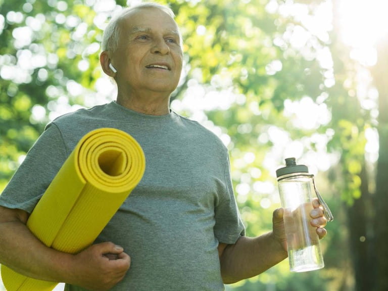 A man with  water bottle and exercise mat ensuring he stays hydrated during exercise |  Shutterstock/BLACKDAY