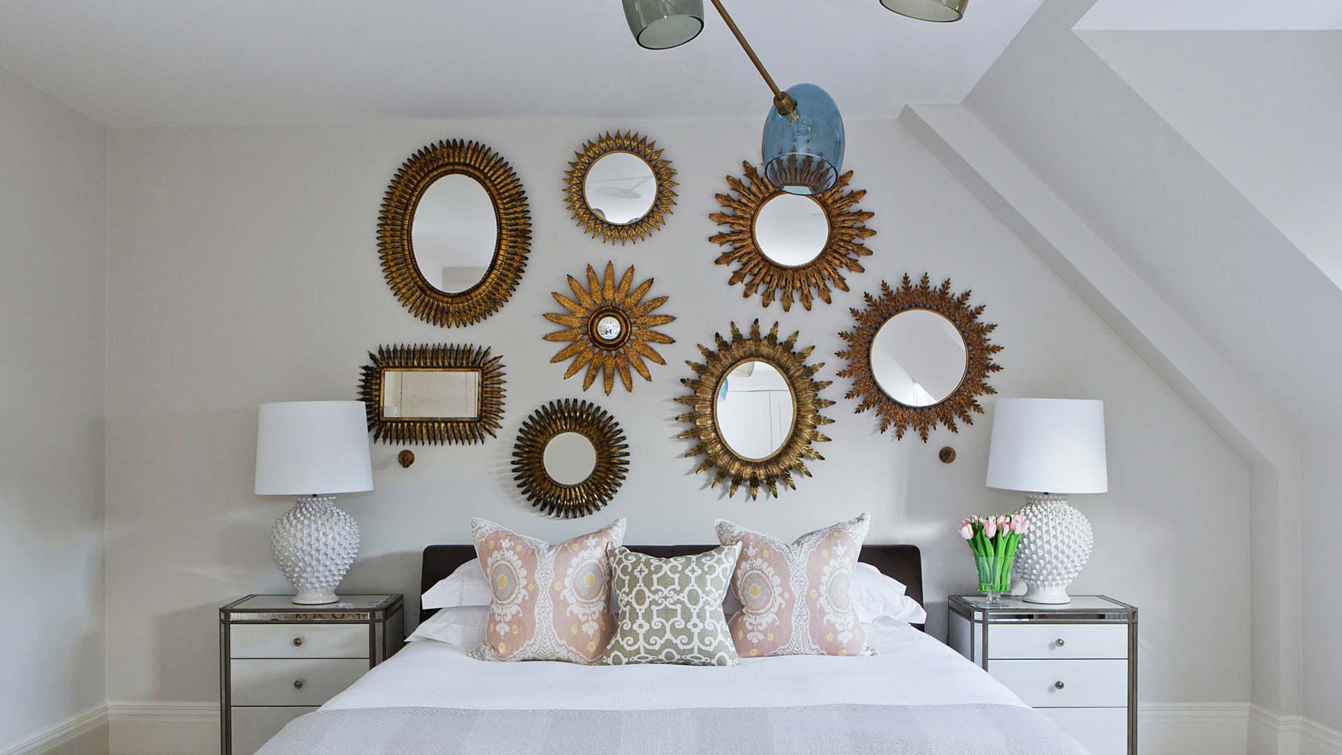 Bedroom with round mirrors above bed