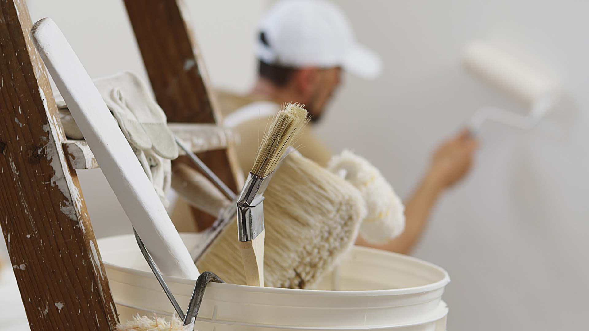 paint brushes and rollers in a bucket