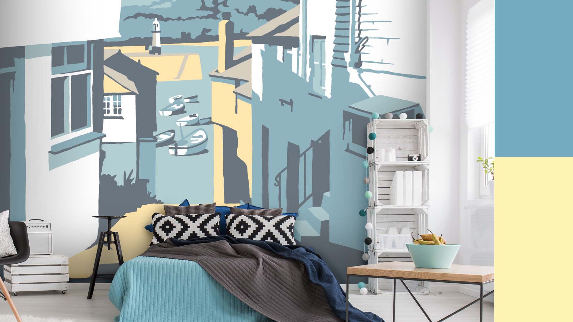 A bedroom with a large wallpaper mural that depicts an illustrated scene of the Cornish town of St Ives.