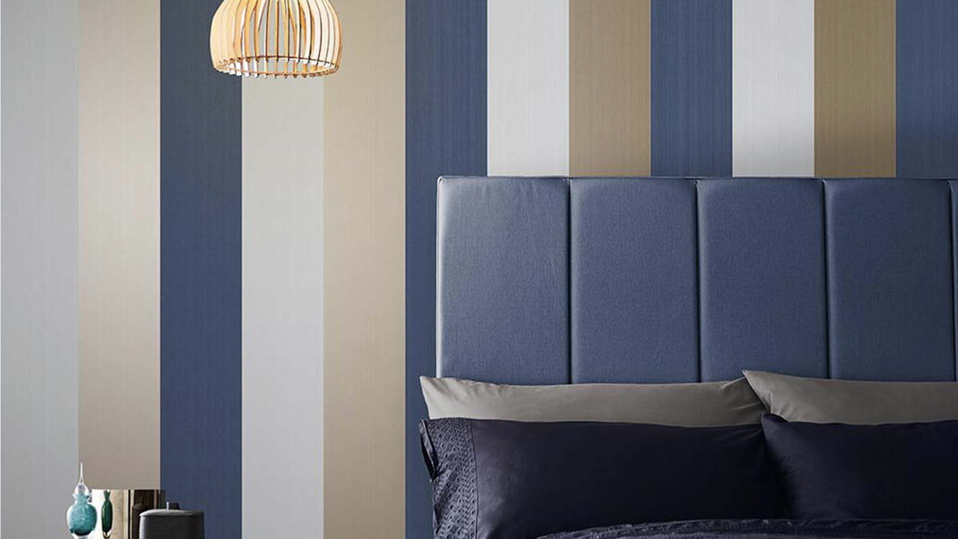 Blue headboard with blue and gold striped wallpaper