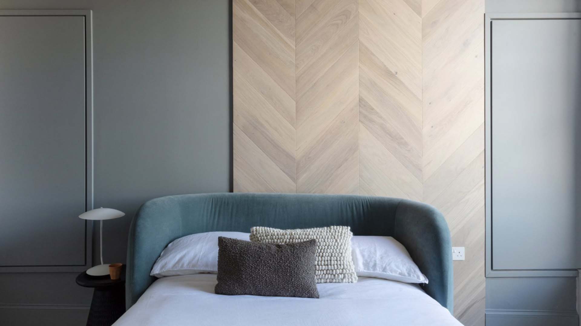 Green curved headboard on a small bed