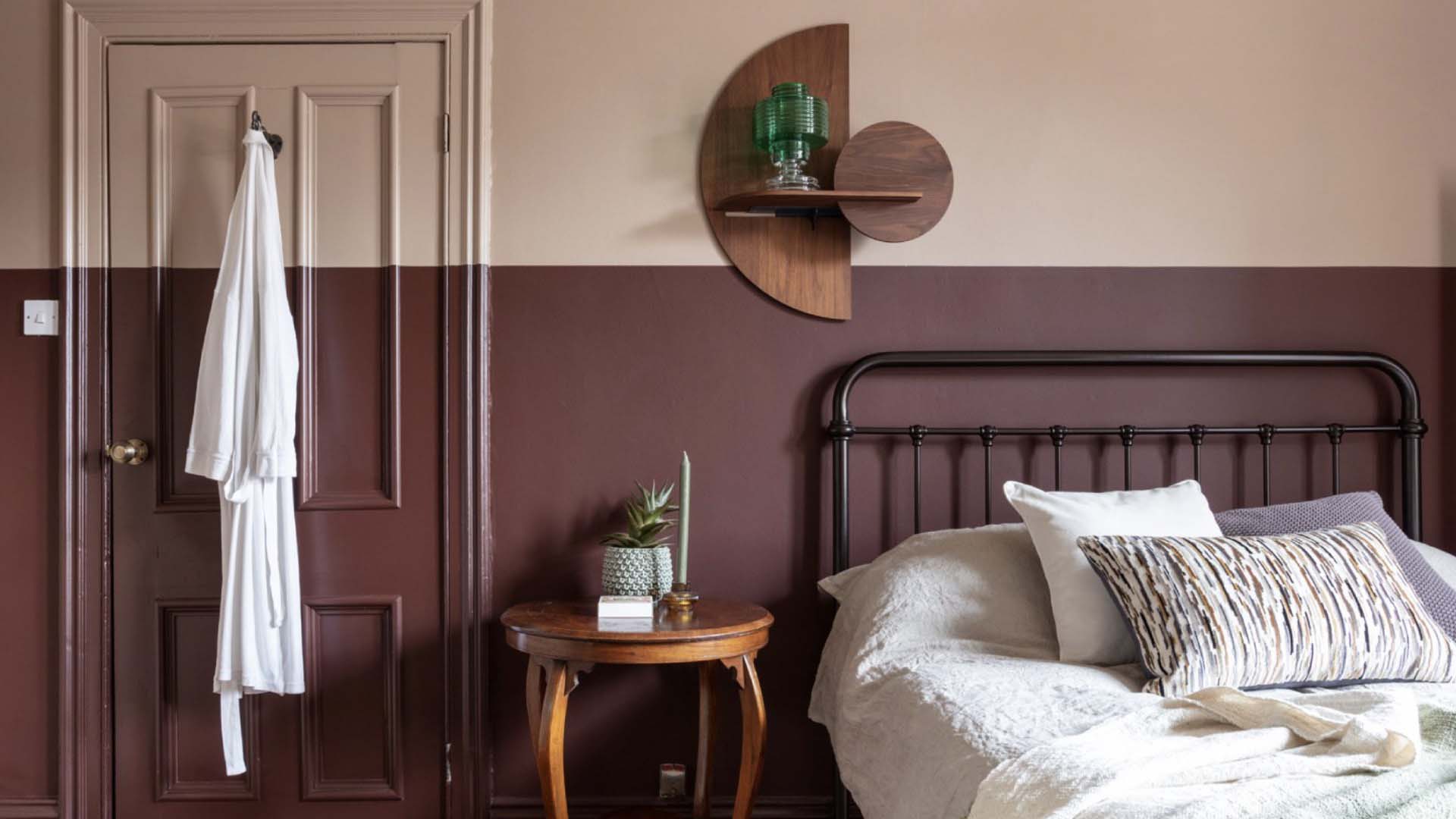 Bed in the corner of the room painted halfway up the wall