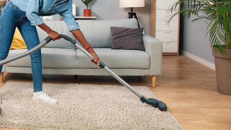 Woman vacuuming a carpet